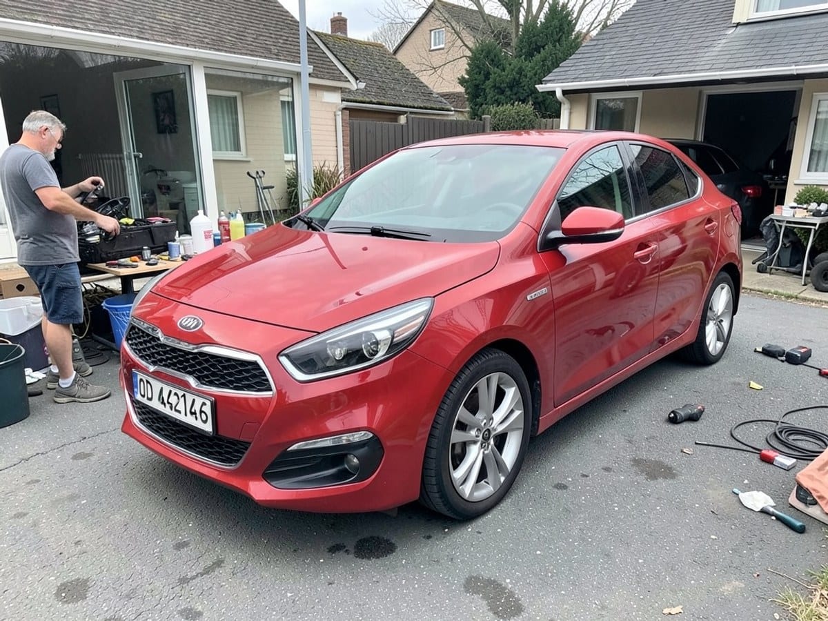 red Kia Sedan with silver grille and rims, parked on a gray surface, is positioned facing left with the license plate "OD 42146".