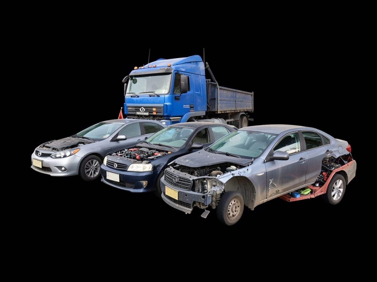 Three cars, in a diagonal line, are displayed against a black background, with a blue truck parked behind the others.