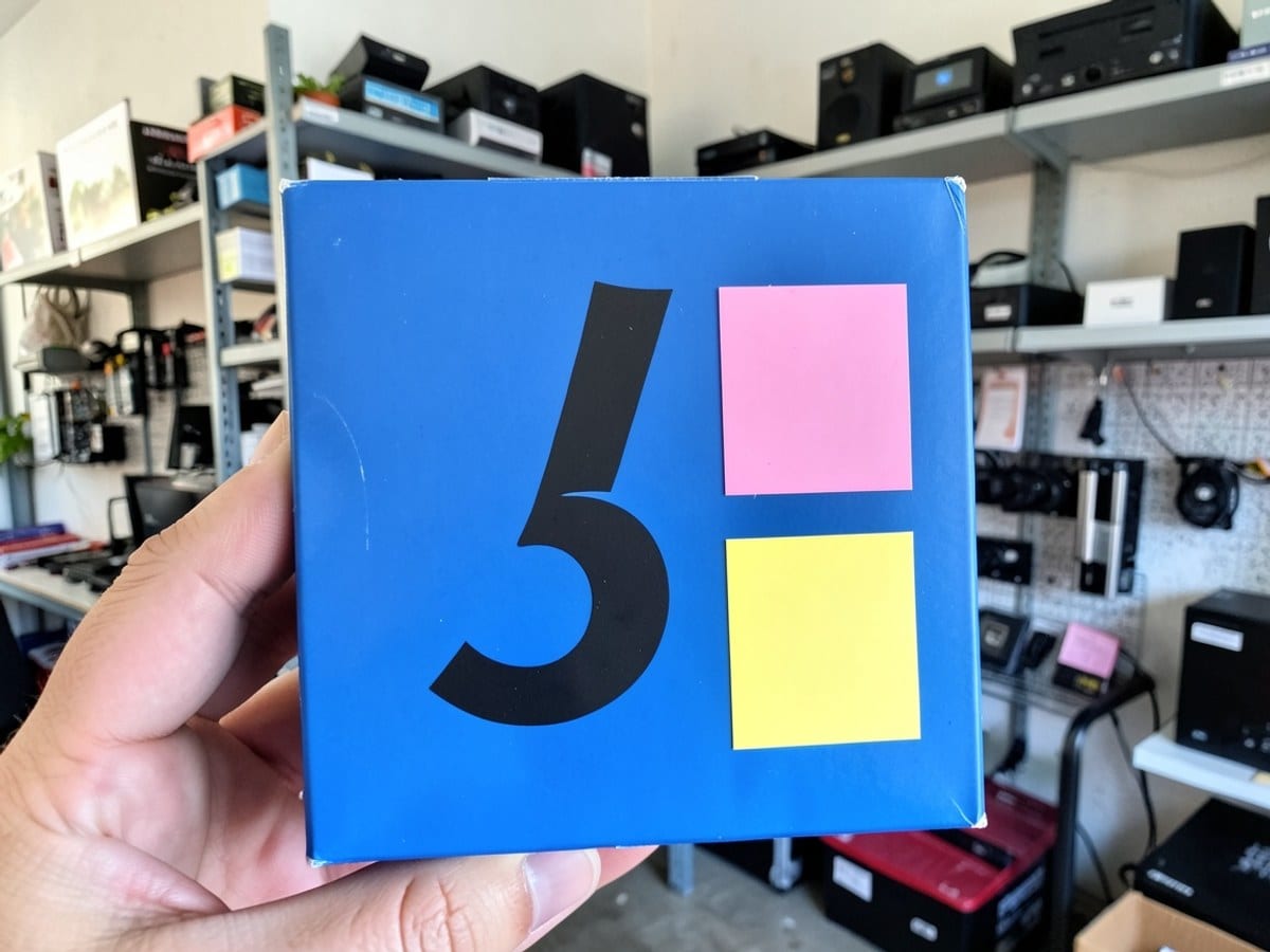 black number 5 is arranged in a blue rectangle with two smaller squares in pink and yellow, showcasing a geometric pattern.